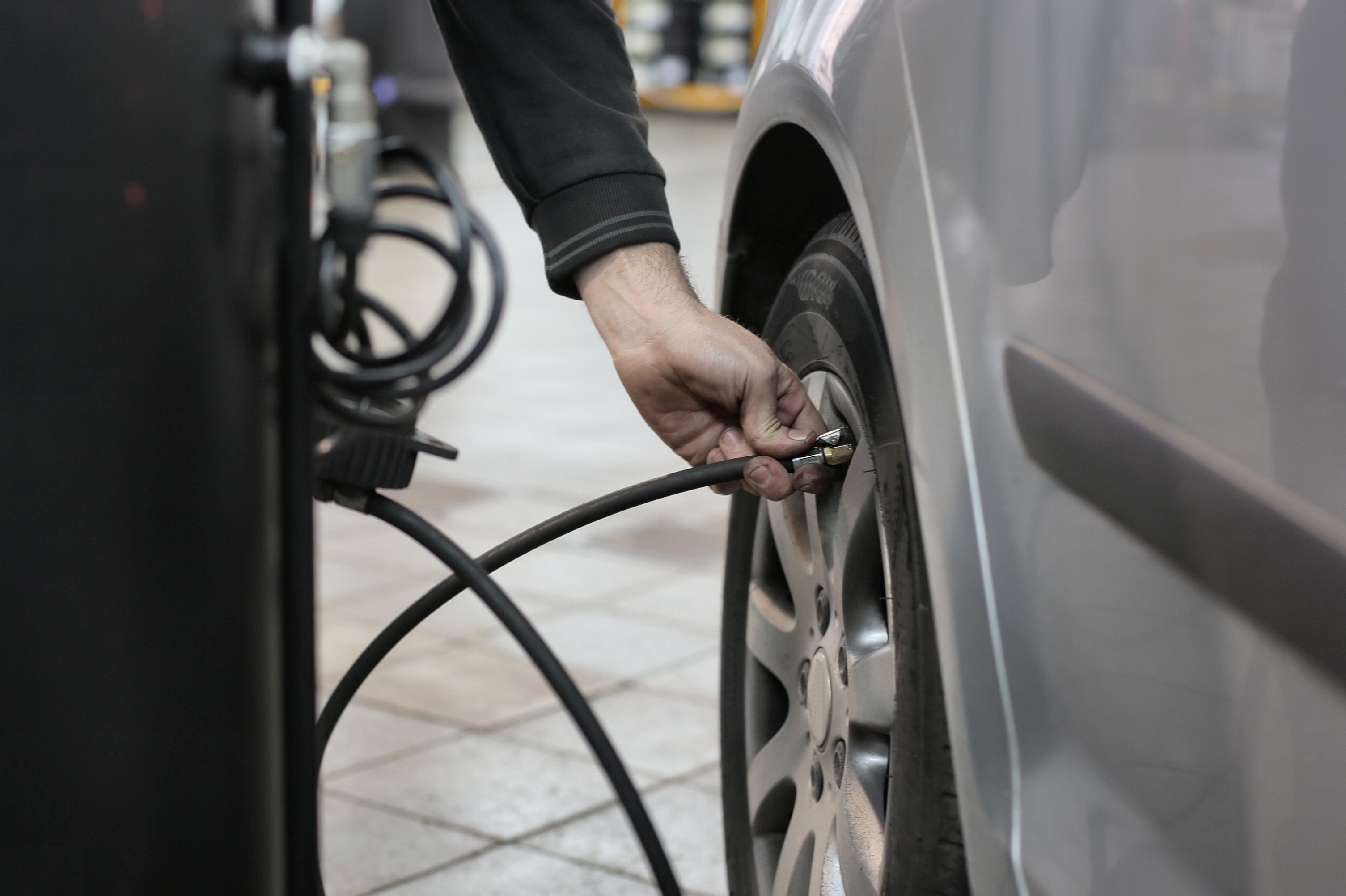 A technician checking tire pressure in a car shop