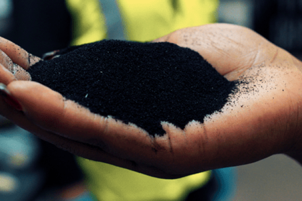 A hand holding micronized rubber powder